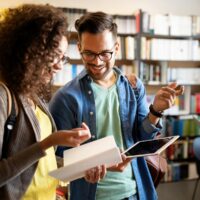 Happy young university students studying together. Group of multiracial people in college